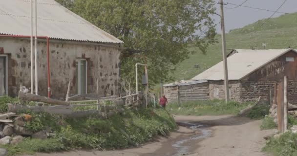 Hombre Caminando Por Camino Suciedad Con Casas Tradicionales Vista Pequeño — Vídeo de stock