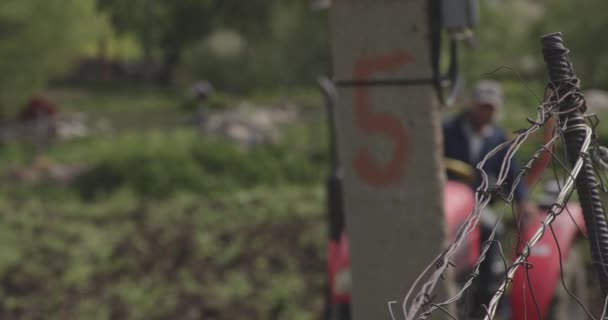 佐治亚州莫里提的一个小村子里 一个农民驾驶着一辆红色拖拉机 用钢丝缠绕在水泥柱子后面的田野里打滚的模糊画像 选择性焦点 — 图库视频影像