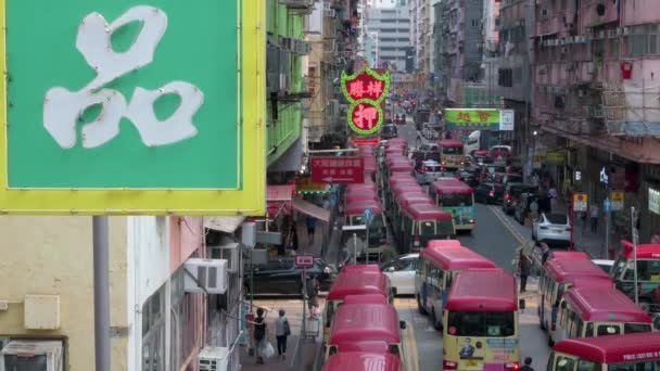前景にはネオンサイン があり 中国人の歩行者 通勤者 バスが香港のモンコク地区の賑やかな通りに位置しています — ストック動画