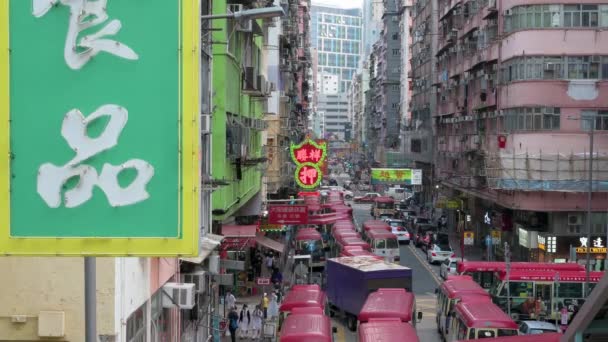 手前にはネオンサイン が見え 香港のモンコック地区の賑やかな通りにミニバスが停まっている — ストック動画
