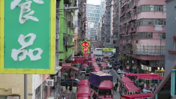 香港の都会的なシーンでは 前景にネオンサイン があり 中国人の歩行者 通勤者 バスがモンコク地区の賑やかな通りに立っています — ストック動画