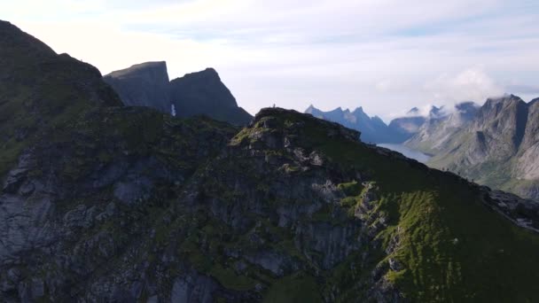 旅行者の上を通過する空中飛行ハイキングや数多くの険しい峰やフィヨルドを明らかにReinebringen山の頂上尾根を歩く ライン ノルウェー — ストック動画