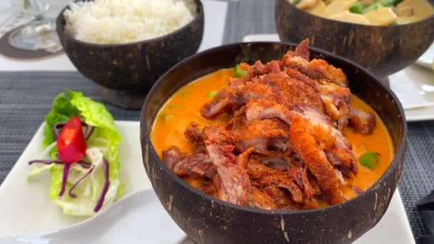 タイの伝統的な赤カレーシャキッとした鴨料理とココナッツボウルにご飯と緑のカレーチキン おいしいタイ料理レストラン 4Kショット — ストック動画