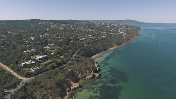 在一个海滨城镇悬崖边的澳大利亚清澈的蓝水上俯瞰着无人驾驶飞机 — 图库视频影像