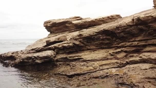 无人机从一个小岩石拱门向外放大 以揭示海洋和海滩 — 图库视频影像