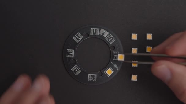 Elektronikkomponenten Mit Pinzette Auf Schwarzer Platine Platzieren — Stockvideo