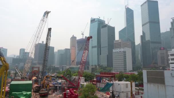 作为重建商业项目的一部分 大型起重机 金属梁和工程设备在建筑工地上工作 而香港金融区的天际线则是背景 — 图库视频影像
