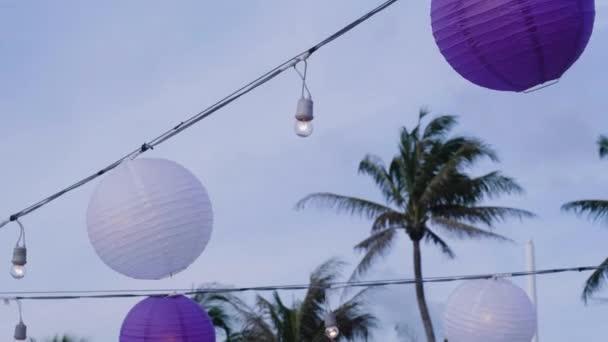結婚式会場で吊るされた紫と白の丸紙の提灯レセプション ローアングルショット — ストック動画
