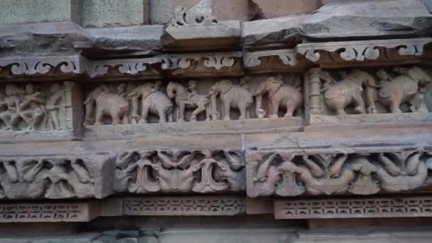 インドのマディヤ プラデーシュ州チャタプールにあるカジュラホ寺院の彫刻された象の作品に触れる女性 ズームアウト — ストック動画