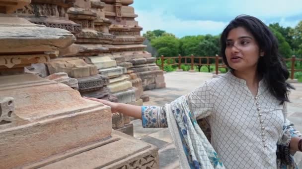 Piękna Hinduska Kobieta Spacerująca Podziwiająca Rzeźbione Kamienie Przed Świątynią Khajuraho — Wideo stockowe