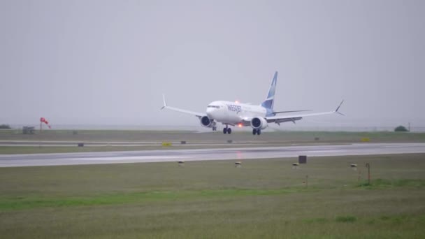 Ett Westjet Passagerarplan Som Landar Våt Bana — Stockvideo