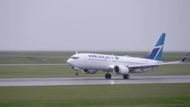 Westjet Boeing 737 Max Lands Wet Runway Tracking View — Stock video