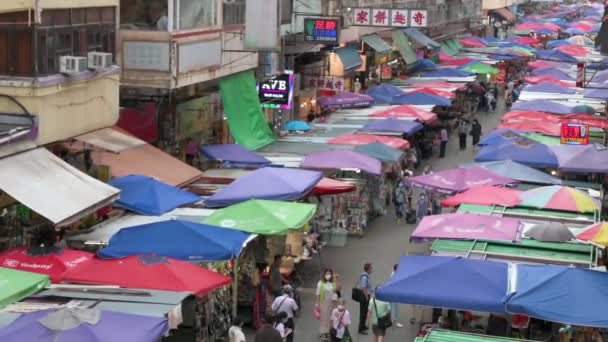 香港で野菜 ギフト ファッショングッズを販売する法園街の屋外市場を歩くと 買い物客のハイビューショット — ストック動画