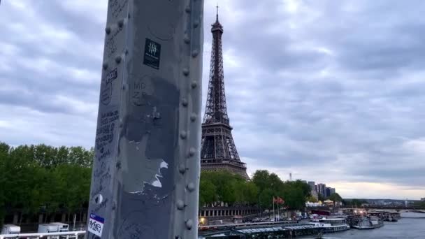 パリのセーヌ川の上のパッセレル デビリー橋 Debilly Footbridge から見える象徴的なエッフェル塔夜 スライダーを上げて — ストック動画