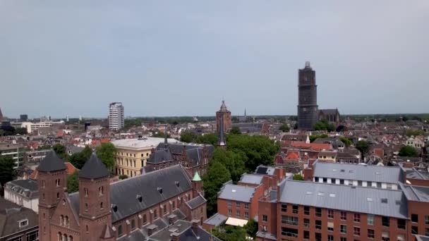 上へ移動ドーム中世の大聖堂の塔の空中ビューは 前景の歴史的な町の屋根と街の上に高くそびえるユトレヒトのオランダの市内中心部の足場 — ストック動画