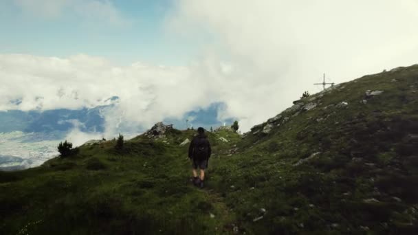 Воздушный Беспилотник Пролетает Над Покрытой Травой Вершиной Горы Молодым Человеком — стоковое видео