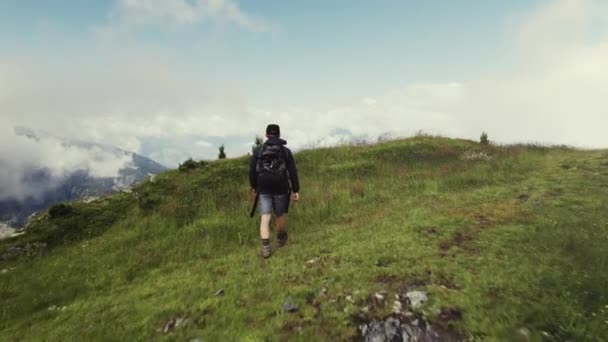 Воздушный Беспилотник Пролетает Над Покрытой Травой Вершиной Горы Человеком Идущим — стоковое видео