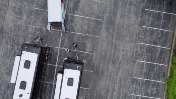駐車場でバスを洗浄し 清掃する労働者 空中ビュー — ストック動画
