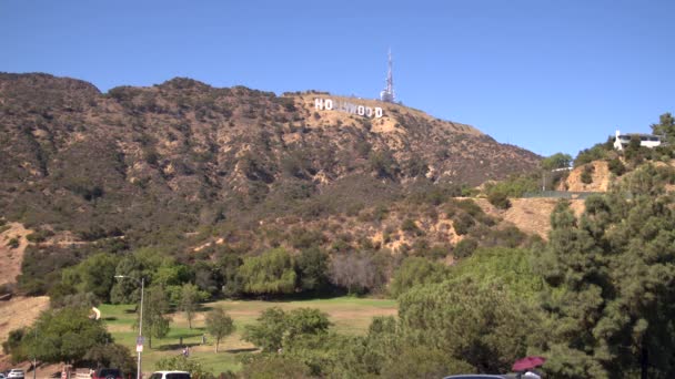 有名なハリウッドサインは カリフォルニア州ロサンゼルスの麓にあるレイクハリウッドパークから見られます 晴れた夏の日に静的ワイドショット 手前に人が見える — ストック動画