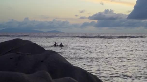 熱帯の島の海岸から日没時にカヤックをする人々 — ストック動画