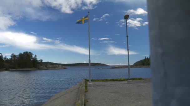 瑞典国旗在湖岸飘扬缓慢的运动揭示了枪声 — 图库视频影像