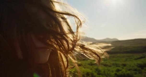 アイスランドの日没時に彼女の髪に風と少女の顔のショットを閉じるゆっくりとした動き — ストック動画