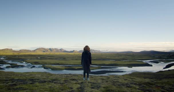 年轻姑娘慢慢地望着夕阳西下的冰原上的山川 — 图库视频影像