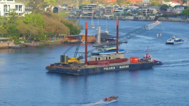 一艘载着起重机的大驳船驶上了河边的一条大船 船舷是一座河边城市的双桅帆船 — 图库视频影像
