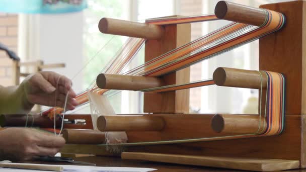 糸はアジアの伝統的な木製の織機の織り装置にループされ クローズアップとして撮影されました — ストック動画