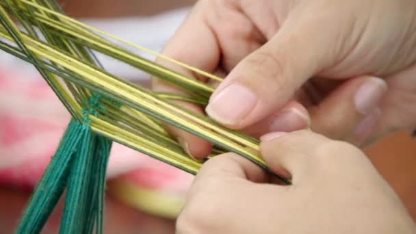 伝統的なアジアのベストを織るための準備として黄色と濃い緑の糸を分離指 極端なクローズアップとして撮影 — ストック動画