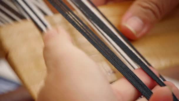 伝統的なアジアの手織りの方法を使用して黒と白の糸を糸を糸と押す指は 極端なクローズアップとして撮影 — ストック動画