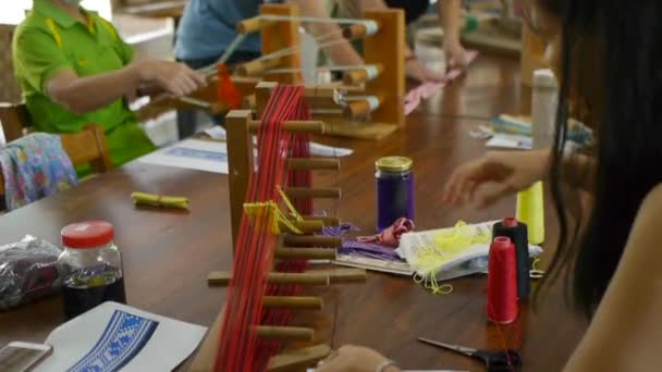 アジアの伝統的な織機製造装置を使ってテーブルの上の人々は 手で撮影されたクローズアップ撮影 — ストック動画