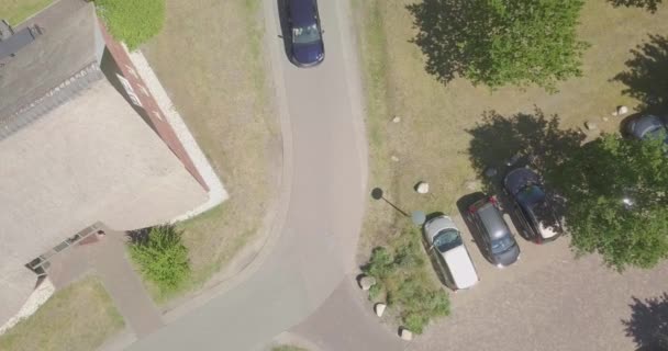 オランダの田舎道を走る濃い青の車の空中静的な禅の景色 — ストック動画