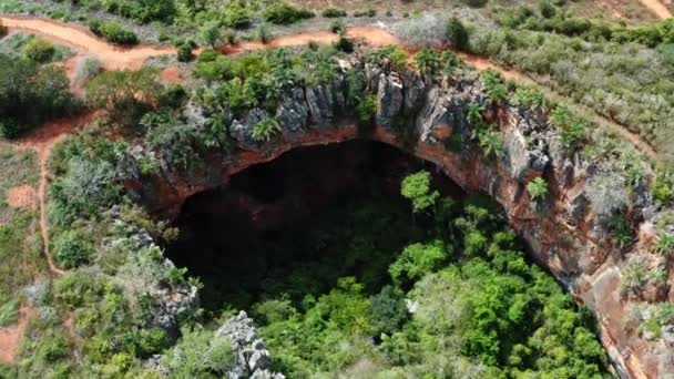 在巴西东北部巴伊亚州的Chapada Diamantina国家公园 空中无人驾驶飞机对彩色岩石的Lapa Doce洞穴入口进行了中空旋转拍摄 这些岩石下方有一个独立的热带雨林 — 图库视频影像