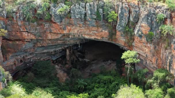 位于巴西东北部巴伊亚州Chapada Diamantina国家公园内 一架无人驾驶飞机从五彩缤纷的岩石构成的巨大的Lapa Doce洞穴入口拍摄了中空照片 这些岩石下方有一个独立的热带雨林 — 图库视频影像