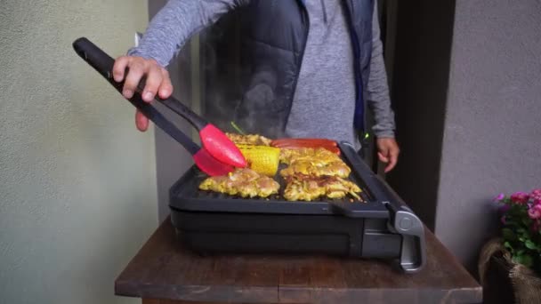 Man Flips Chicken Meat Electric Griller Silicone Food Tongs Close — Stock Video