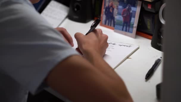Χέρι Ενός Νεαρού Άντρα Χειρόγραφες Σημειώσεις Στο Γραφείο Στην Αίθουσα — Αρχείο Βίντεο