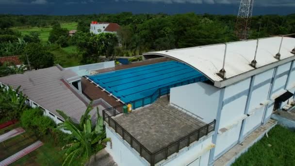 インドネシアのジャングルの中で曇りの日に空のオリンピックサイズの屋外スイミングプール — ストック動画