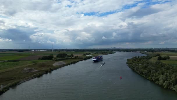 貨物線コンテナ船の空中追跡ショットBgオニキスは遠くの広大な風景や都市を通ってZwijndrechtの川を渡って航海します — ストック動画
