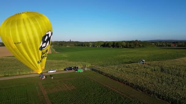 オランダの飛行場で準備中の明るい黄色の熱気球の空中朝の眺め 円ドリー — ストック動画