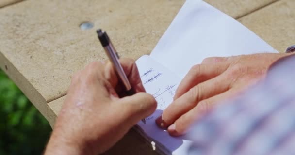 Πάνω Από Την Όψη Ώμου Του Ανθρώπου Χέρια Γράφοντας Σημειώσεις — Αρχείο Βίντεο