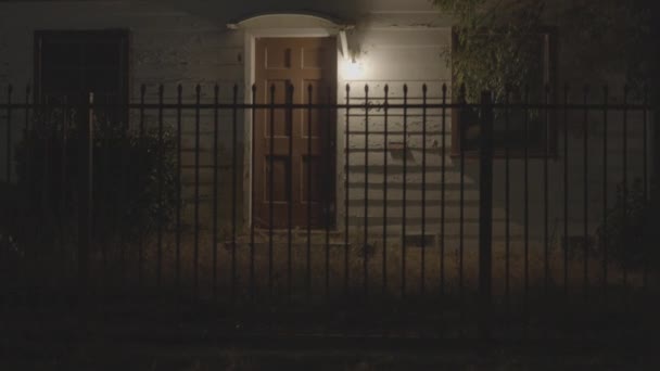 夜间在城里一座房子的静止不动的镜头 有人看见房子前面有铁栅栏 有人看见一辆汽车经过 — 图库视频影像