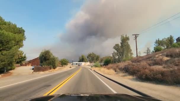 カリフォルニアのフェアビュー火災への道 遠くでは 破壊的な昼間の火災から煙の厚い梅 道路上で近づいて移動車からの眺め 避難した住民を — ストック動画