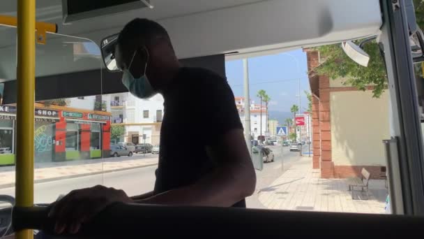 人々はマラガにバスに乗っている 老婦人が通りの外にいる 車が通りを通っている バスにはフェイスマスクをしている人がいる 老人がバスの運転手に金を払ってる — ストック動画