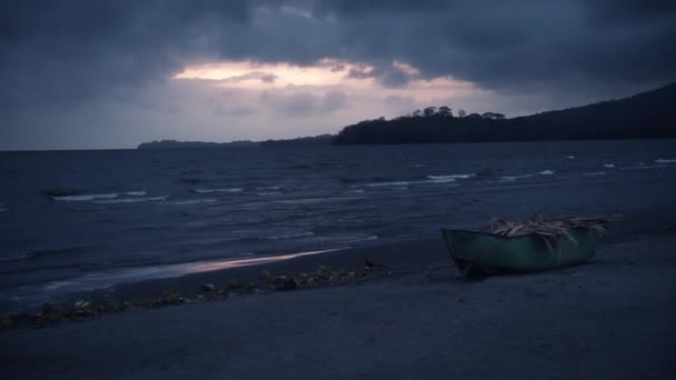 在一个阴沉沉的早晨日出时分在海滩上的一艘船 — 图库视频影像