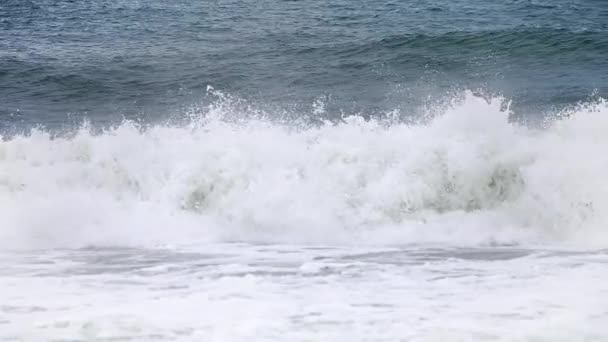 海岸のゆっくりとした動きの中で小さなクラッシュ波からの白い水のパンとその背後に深い濃い青の海と高速カメラ120Fpsの4K映像でこぼれる白い水 — ストック動画