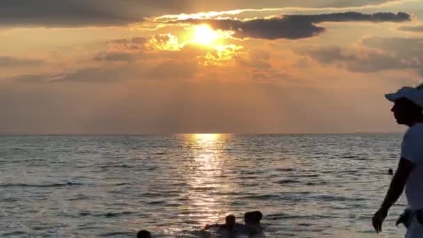 Sylwetka Mężczyzny Sprzedającego Słodkie Pączki Spacerującego Plaży Zachodzie Słońca Dzieci — Wideo stockowe