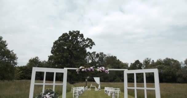 Широкий Вид Через Свадебную Арку Между Украшенными Стульями Свадебной Церемонии — стоковое видео