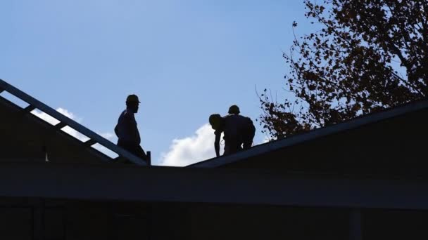 Helyhez Kötött Felvétel Ház Tetején Dolgozó Építőmunkások Sziluettjéről — Stock videók