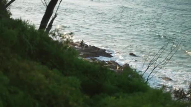 商人坐在海滩岩石上与海浪擦肩而过的头像 — 图库视频影像